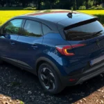 Achterkant driekwart aanzicht van blauwe 2025 Renault Captur met transparante achterlichten en moderne achterkant styling