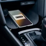 2025 Toyota Yaris Cross draadloze oplaadpad in middenconsole met smartphone die oplaadstatus en batterij-indicator toont