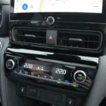 2025 Toyota Yaris Cross klimaatregelpaneel met dual-zone automatisch systeem met digitale temperatuurweergaves en fysieke bedieningen