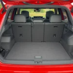 Open achterklep zicht van 2025 Volkswagen Tiguan met grote laadruimte, vlakke vloer, zijbergvakken en zichtbare achterbankleuningen