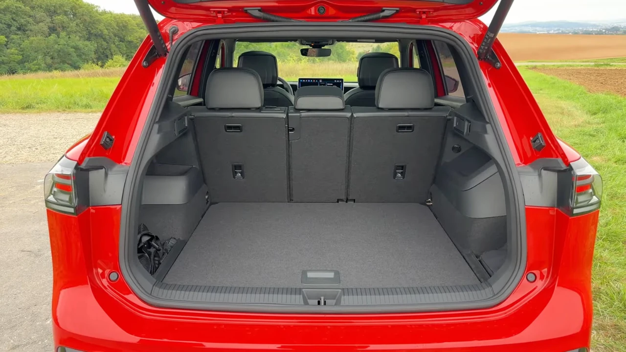Open achterklep zicht van 2025 Volkswagen Tiguan met grote laadruimte, vlakke vloer, zijbergvakken en zichtbare achterbankleuningen