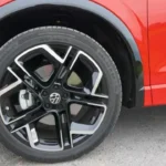 Gedetailleerde close-up van 2025 Volkswagen Tiguan lichtmetalen wiel met spaakdesign, band zijkant en VW merkcentrale dop