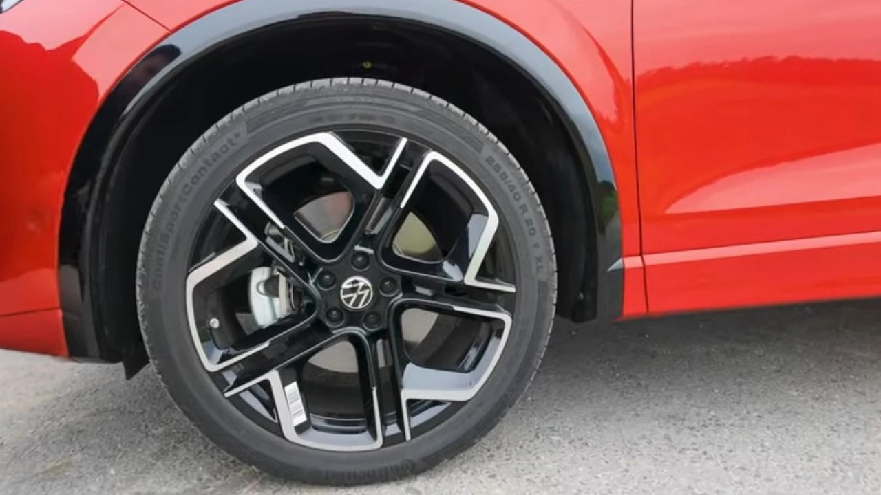 Gedetailleerde close-up van 2025 Volkswagen Tiguan lichtmetalen wiel met spaakdesign, band zijkant en VW merkcentrale dop