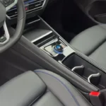 Middenconsole van 2025 Volkswagen Tiguan met draaiknoppen-versnellingspook, bekerhouders, opbergruimtes met blauwe siernaad
