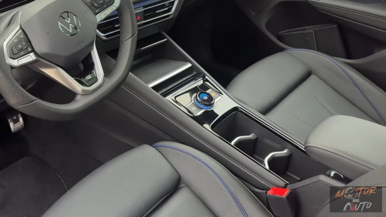 Middenconsole van 2025 Volkswagen Tiguan met draaiknoppen-versnellingspook, bekerhouders, opbergruimtes met blauwe siernaad