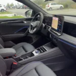 Passagierszijde zicht van 2025 Volkswagen Tiguan interieur met dashboard design, blauwe sfeerverlichting en grijze bekleding