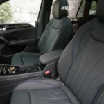 Voorstoelen van 2025 Volkswagen Tiguan met grijze leren bekleding met blauwe siernaad en ergonomisch ontwerp voor passagierscomfort