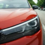 Gedetailleerd zicht van 2025 Volkswagen Tiguan rode voorsectie met LED-koplamp met kenmerkende lichtsignatuur en aerodynamisch motorkap design