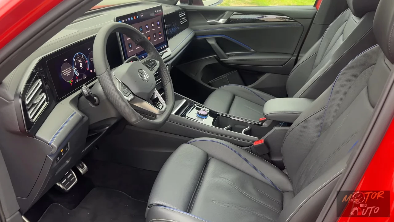 Voorstoel zicht van 2025 Volkswagen Tiguan interieur met grijze leren stoelen, middenconsole met draaiknoppen-versnellingspook en blauwe details