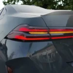Gedetailleerde close-up van 2025 BMW M5 achter LED-verlichting met rode remlichten en amber richtingaanwijzers met zichtbaar BMW-logo