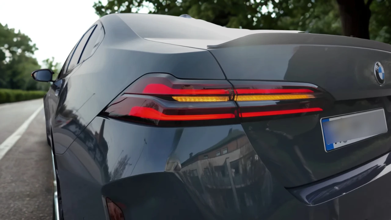 Gedetailleerde close-up van 2025 BMW M5 achter LED-verlichting met rode remlichten en amber richtingaanwijzers met zichtbaar BMW-logo