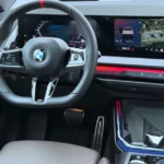 Bestuurders cockpit van de 2025 BMW X3 M50 met iDrive 9 interface en ambiance verlichting