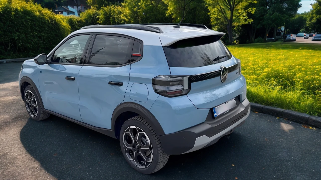 Lichtblauwe 2025 Citroën ë-C3 elektrische auto vanuit achter driekwart hoek met moderne LED-achterlichten, geïntegreerde achterspoiler, kenmerkende lichtmetalen velgen en crossover carrosserie-styling