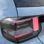 Close-up van 2025 Citroën ë-C3 achter-LED-achterlicht met modern design met rode verlichting, kenmerkend lichtpatroon en integratie met het lichtblauwe achtercarrosseriepaneel