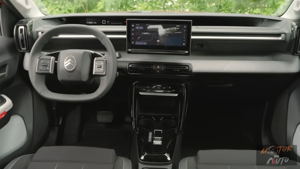 2025 Citroën ë-C3 dashboard-beeld met centraal touchscreen display, modern stuurwiel met Citroën-logo, grijze interieurdetails en minimalistisch dashboard-design