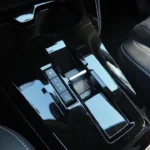 Gedetailleerd beeld van 2025 Citroën ë-C3 automatische versnellingsselector met P-R-N-D-C standen weergegeven, glanzende zwarte afwerking en moderne elektronische schakelaar-design