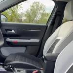 Close-up van 2025 Citroën ë-C3 voorstoelen met gewatteerde stoffen bekleding in grijze en zwarte kleuren met wit contrastgaren en modern stoeldesign