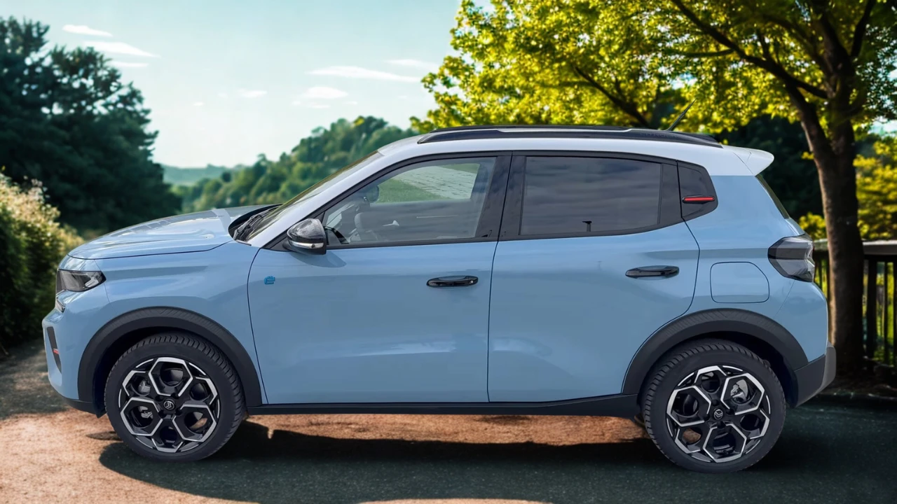Volledig zijaanzicht van lichtblauwe 2025 Citroën ë-C3 elektrische crossover met verhoogde rijhoogte, zwarte wielkasten bekleding, geometrische lichtmetalen velgen en compacte SUV-proporties