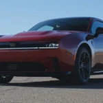 Het exterieurontwerp van de 2025 Charger Daytona getoond in natuurlijk daglicht, met nadruk op de rode lak en atletische houding