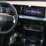 Gedetailleerd zicht op het dashboard van de Opel Frontera met dual screens, stuurwielbediening en centrale ventilatieroosters