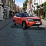 De 2025 Opel Frontera in levendig oranje toont zijn moderne Vizor-design in een typische Nederlandse winkelstraat