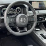 2025 Nissan Qashqai interieur met dashboard met digitale displays, stuurwiel met Nissan-logo, middenconsole en modern cabineontwerp