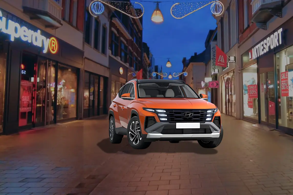 Een vooraanzicht van de Hyundai Tucson uit 2025, geparkeerd in een stadsstraat 's nachts.