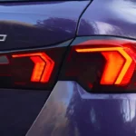 2025 BMW 1 Serie 120i achterlicht detail met modern LED-ontwerp met oranje en rode elementen, modelbadge en premium paarse metallic lakafwerking