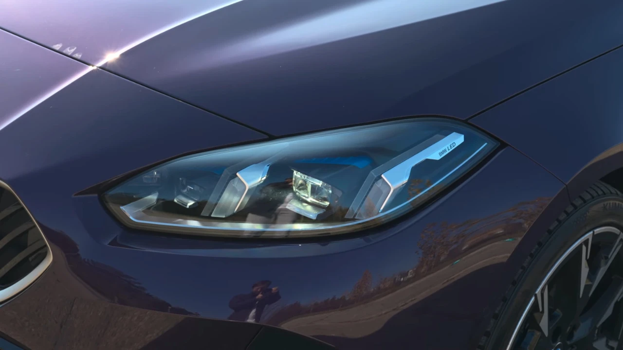 2025 BMW 1 Serie LED-koplamp close-up met geavanceerde verlichtingstechnologie met blauwe accenten, complex lensontwerp en moderne automotive verlichting innovatie in paarse metallic