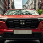 2025 Honda CR-V rode SUV voorgrill close-up met honingraat patroon en Honda logo op stadsstraat