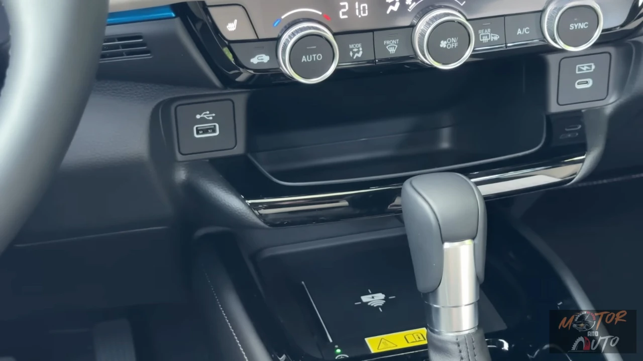 2025 Honda HR-V middenconsole met USB-oplaadpoorten, opbergvakken, automatische versnellingspook en draadloos oplaadpad voor smartphone-connectiviteit.