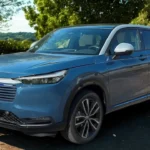 2025 Honda HR-V voor driekwart hoek in blauw met Honda's kenmerkende grille, LED-koplampen, mistlampen en eigentijdse SUV-styling elementen.