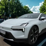 Voor-driekwart aanzicht van witte 2025 Polestar 4 elektrische SUV op stadsstraat met bomen op de achtergrond, toont voor-LED-verlichtingsontwerp en moderne aerodynamische styling