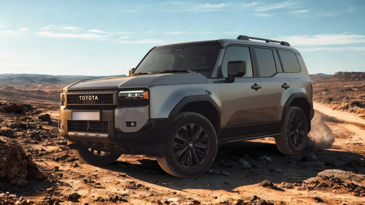 Zijprofiel van grijze 2025 Toyota Land Cruiser gepositioneerd op woestijnterrein met dramatische zonsondergang verlichting en berg silhouetten op achtergrond