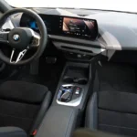 Interieurweergave van de BMW 1 Serie 2025 met het nieuwe gebogen display dashboard en moderne cockpit-indeling