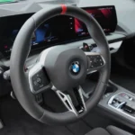 M Sport stuurwiel en digitale cockpit van de BMW 1 Serie 2025 met rode accentdetails