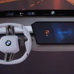 BMW's nieuwe Panoramische iDrive-systeem met het minimalistische witte stuurwiel en welkomstscherm op het centrale display