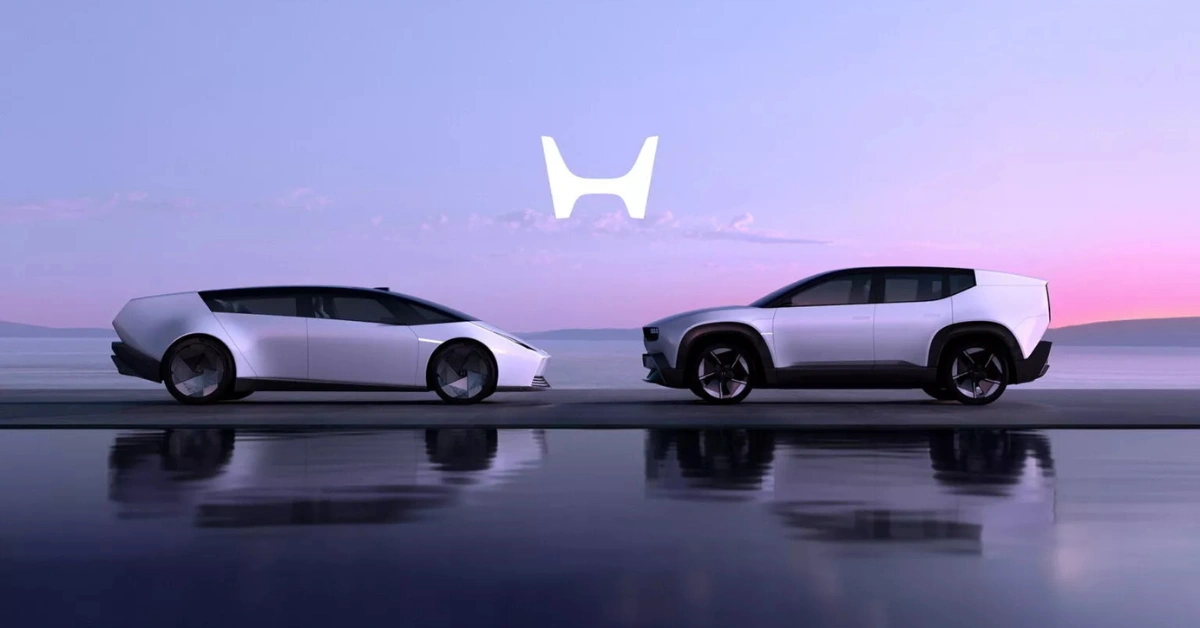 Zijaanzicht van Honda's nieuwe 0 Serie EV's met de laag gebouwde Saloon (links) en hogere SUV (rechts) tegen een paarse zonsondergang achtergrond met verlicht Honda logo