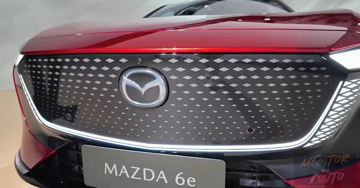 Close-up van de kenmerkende ruitpatroon verlichte grille van de Mazda 6e met geïntegreerd Mazda-logo