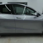 Volledig zijaanzicht van de Tesla Model Y met nadruk op de gestroomlijnde proporties en nieuwe aerodynamische wielen