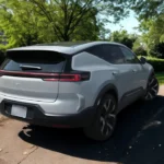 Witte 2025 Polestar 3 elektrische SUV achteraanzicht op parkpad omgeven door groene bomen en landschapsarchitectuur