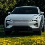 Witte 2025 Polestar 3 elektrische SUV vooraanzicht geparkeerd in park met groene bomen en gouden herfstbladeren op de achtergrond