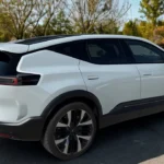 Witte 2025 Polestar 3 elektrische SUV zijaanzicht in herfstparkomgeving met kleurrijk herfstgebladerte en bomen