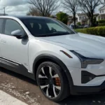 Witte 2025 Polestar 3 elektrische SUV zijprofielaanzicht in woonstraat met huizen en bomen op de achtergrond