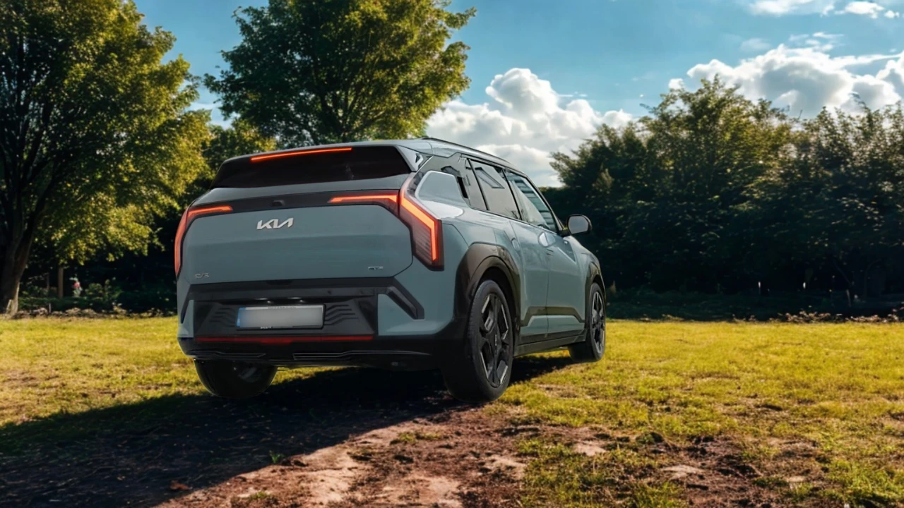 Lichtblauwe 2025 Kia EV3 elektrische SUV in achter-driekwart aanzicht geparkeerd op gras in een park met bomen en blauwe lucht achtergrond