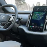 Dashboard-aanzicht met stuurwiel, digitaal display en Google navigatiesysteem