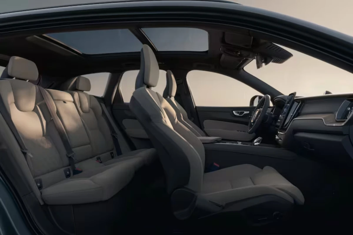 Zijaanzicht van het XC60 2025 interieur met voor- en achter lederen stoelen en panoramadak