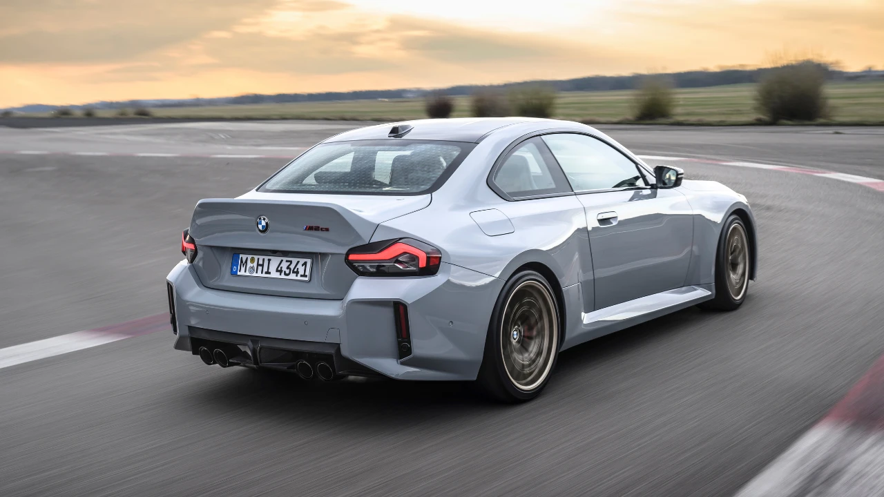 Achter drie-kwart zicht van 2025 BMW M2 CS met geïntegreerde eendenstaart spoiler, koolstofvezel achterdiffuser, viervoudige uitlaatpijpen, en M2 CS badge met rode omlijning