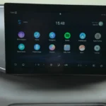 De BYD Dolphin Surf beschikt over een modern 10,1-inch draaibaar touchscreen met Android Auto, Apple CarPlay, Spotify en BYD DiLink multimediasysteem. De interface toont apps waaronder navigatie, mediacenter en voertuiginstellingen met intuïtieve touchbediening.