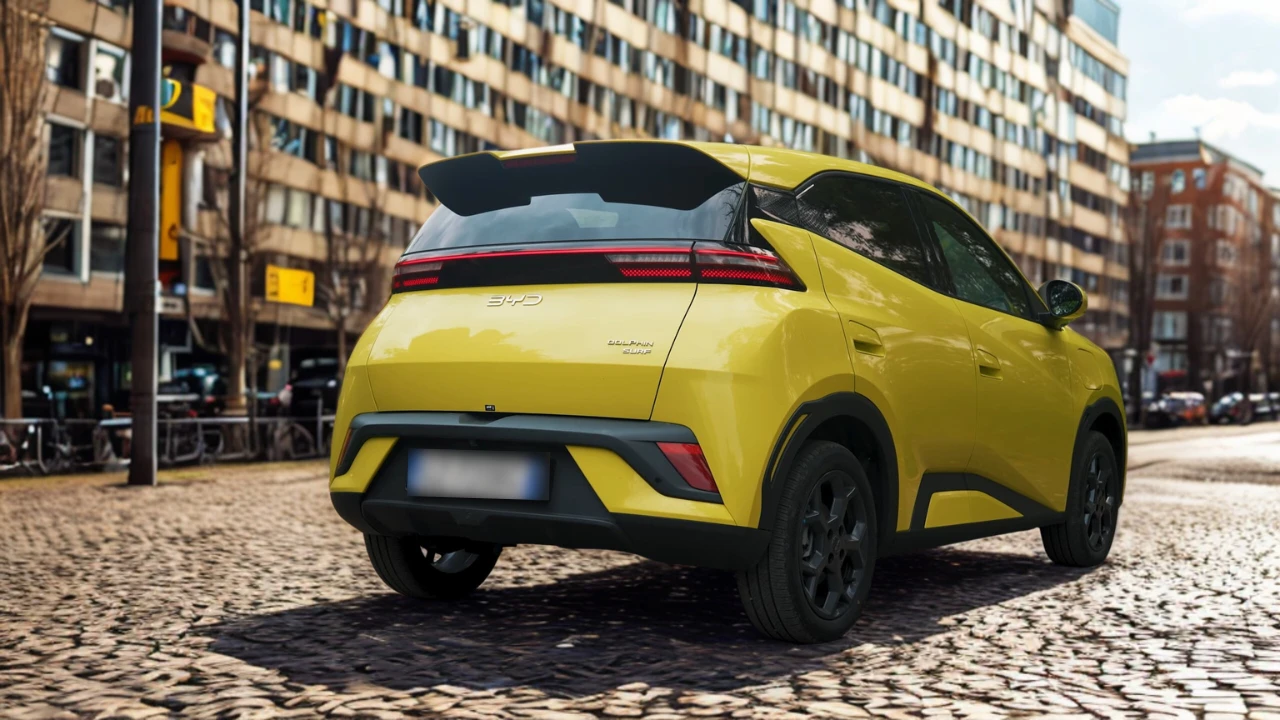 2025 BYD Dolphin Surf in Limoengroene kleur met achter driekwart zicht met LED-achterlichten, spoiler en stedelijke achtergrond